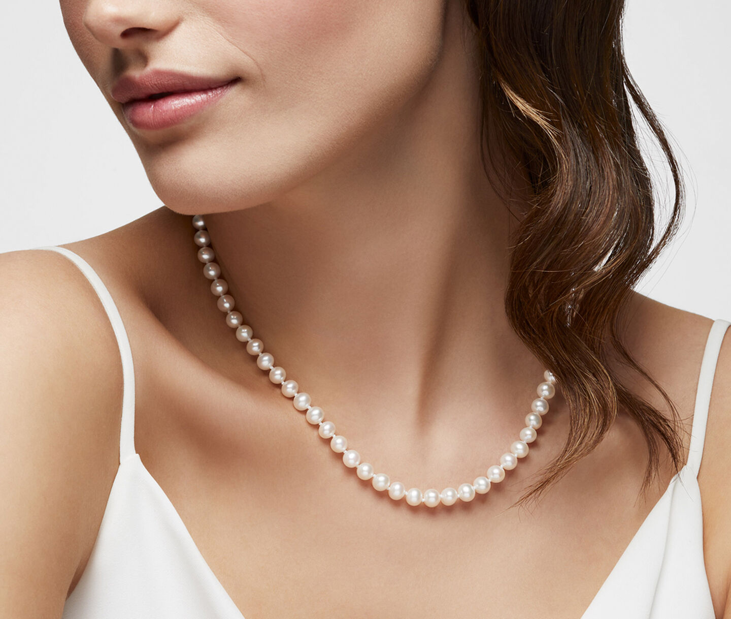 A woman wearing a Birks Pearls necklace.